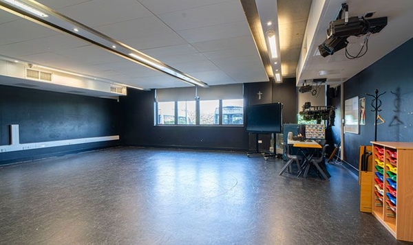 Love Locations black box drama studio South East London: Dark-painted performing arts rehearsal room with sleek ceiling strip lights, optimized for independent film sets and music videos.
