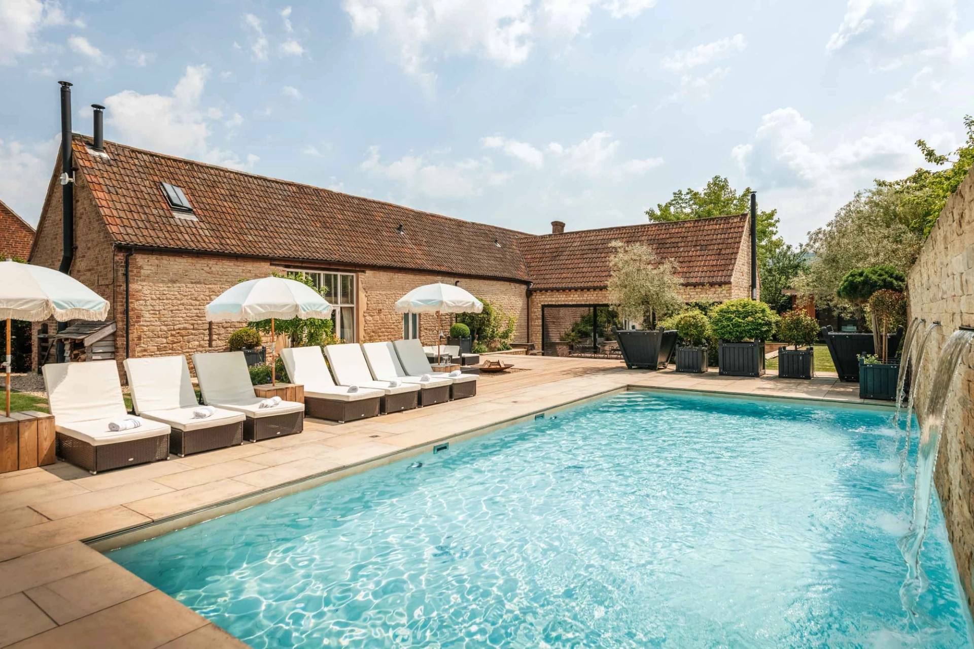 Wide shot of an outdoor swimming pool terrace and stone country residence backdrop for brand shoots from Love Locations.