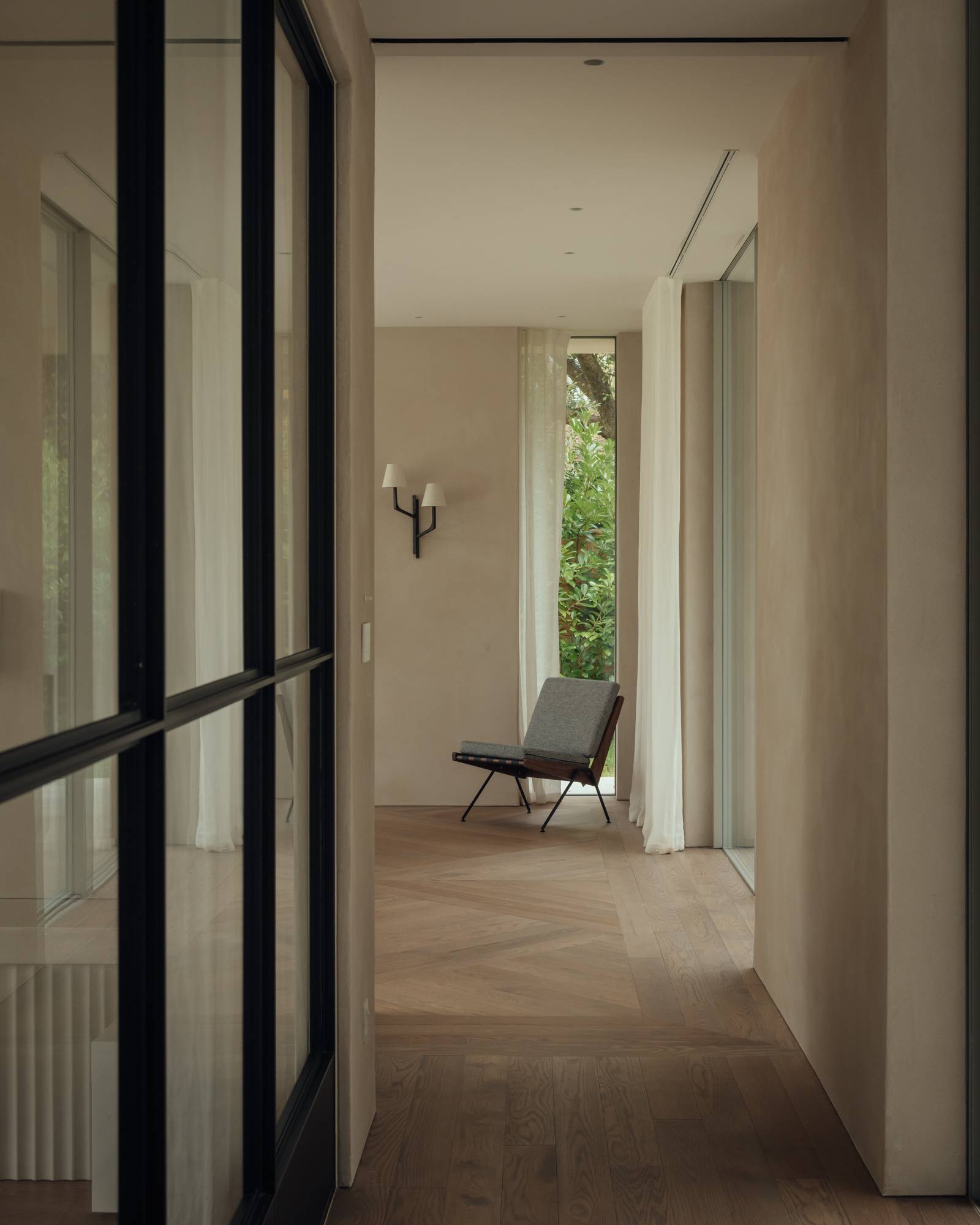 Spacious modern hallway showing black glass doors, light oak parquet floorboards, and clean architectural lines, ideal for film location scouting, Love Locations.