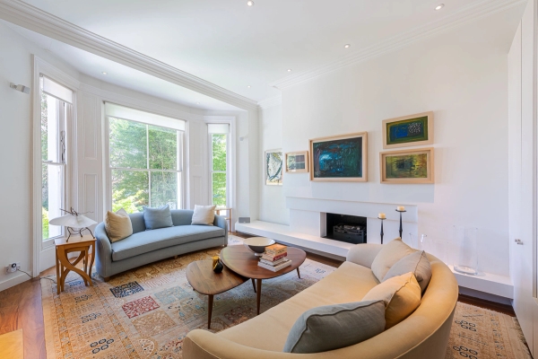 Bright formal reception room showcasing elegant alcove shelving, a central fireplace hearth, and a curved cream sofa, perfect for luxury lifestyle shoots, Love Locations W4.