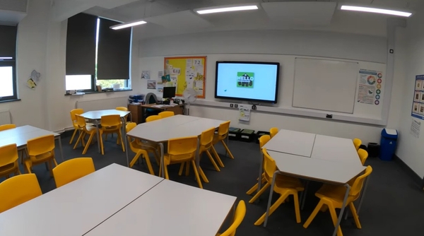 Love Locations contemporary school classroom RG30: Classroom corner showing group tables, yellow seating, and an active digital smartboard, great for e-learning promotions and corporate ads.