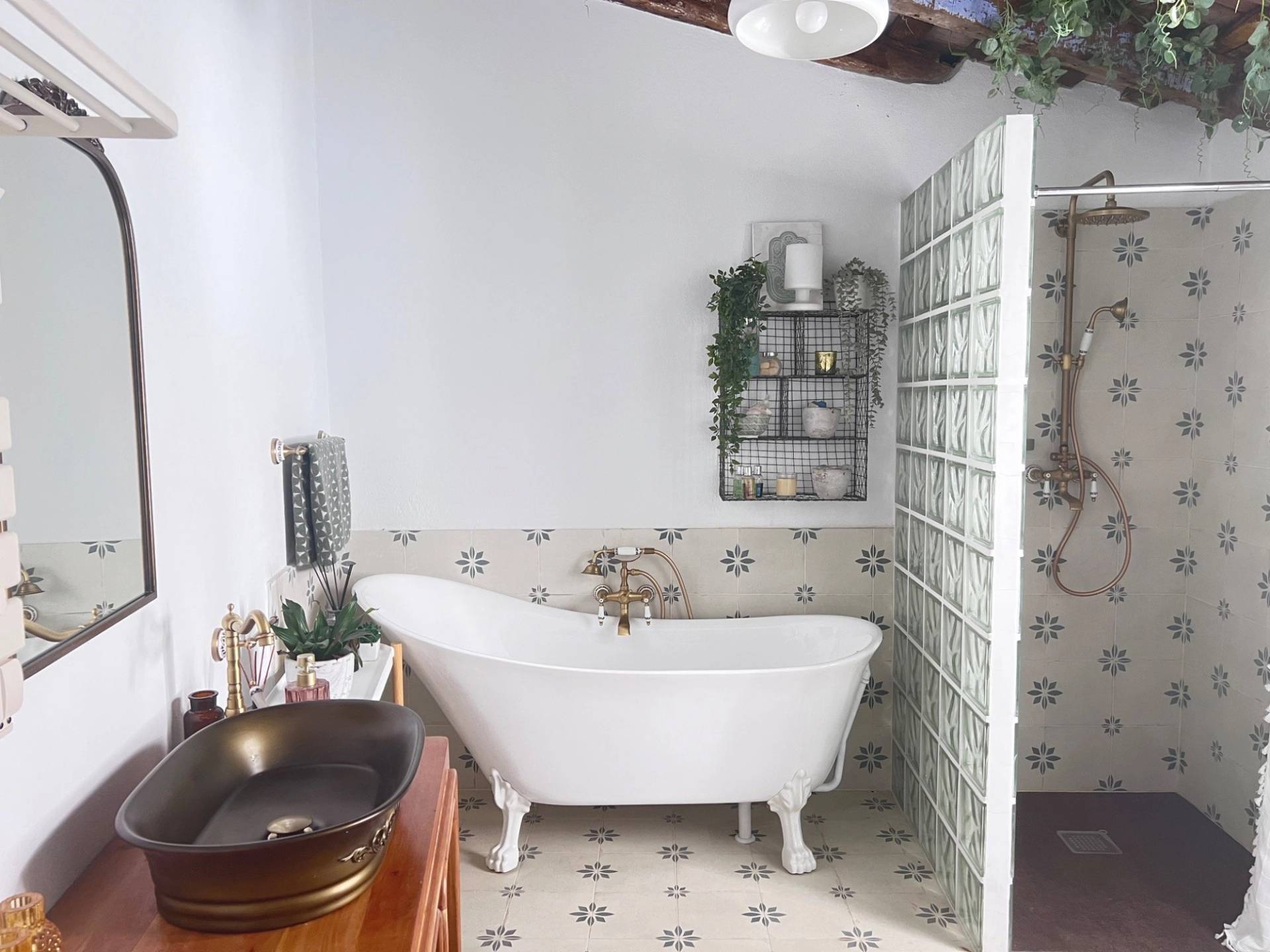 Vintage style bathroom film location in Jimena de la Frontera Cádiz from Love Locations, featuring a freestanding clawfoot bathtub, patterned tiles, and a wooden vanity unit.