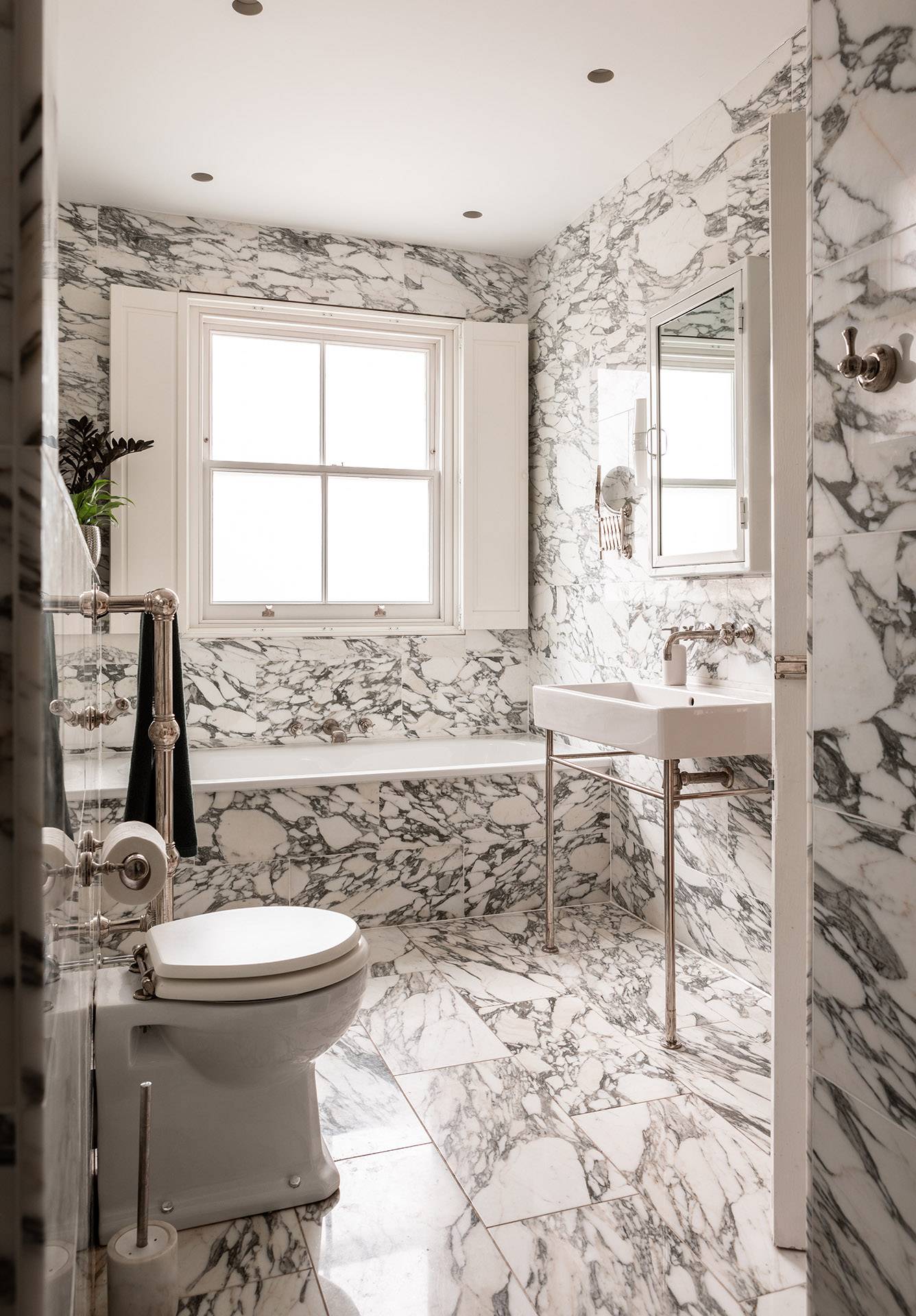 Luxury marble bathroom with a freestanding tub, vintage towel warmer, and shuttered sash window, perfect for spa brand advertising, Love Locations TW1.