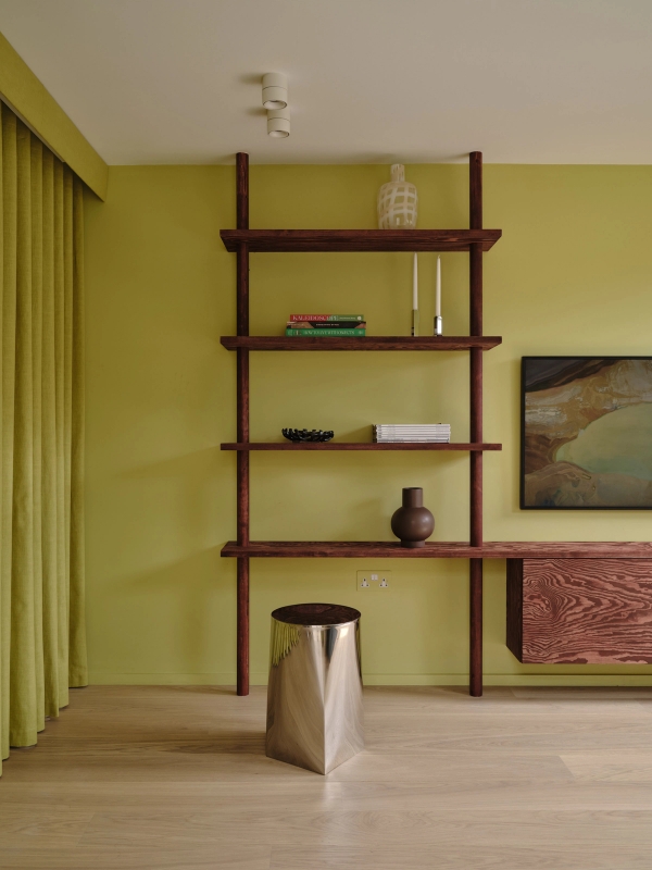 Love Locations high-end wood joinery location Lewisham: Minimalist floating timber wall unit displaying artistic ornaments against a lime green painted canvas backdrop.
