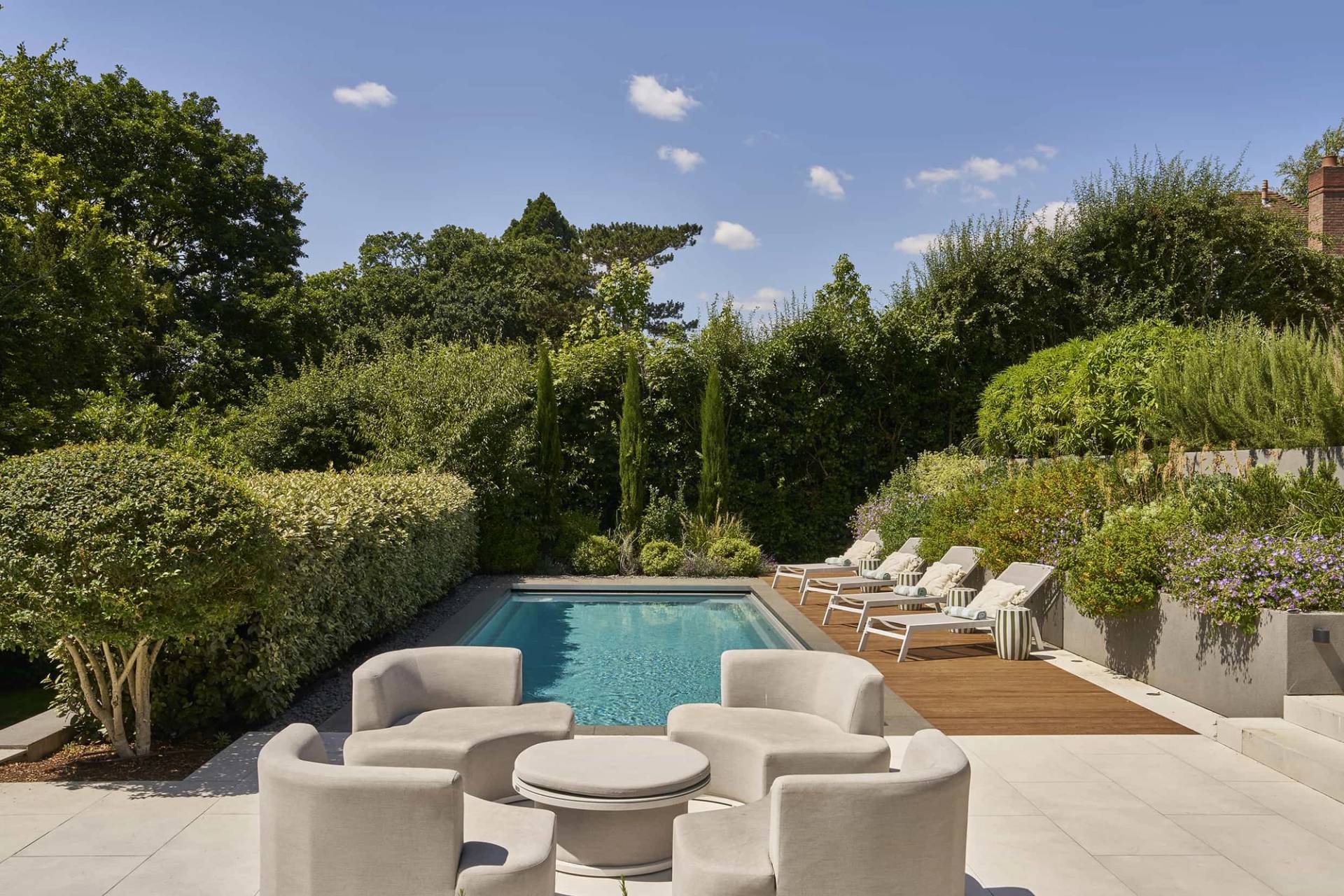 Designer outdoor swimming pool with stone paving and architectural plant borders, perfect for summer shoots, Love Locations.