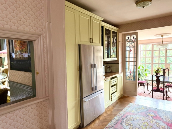 Yellow kitchen cabinets with stainless steel American fridge freezer and floral runner rug, Love Locations N13.