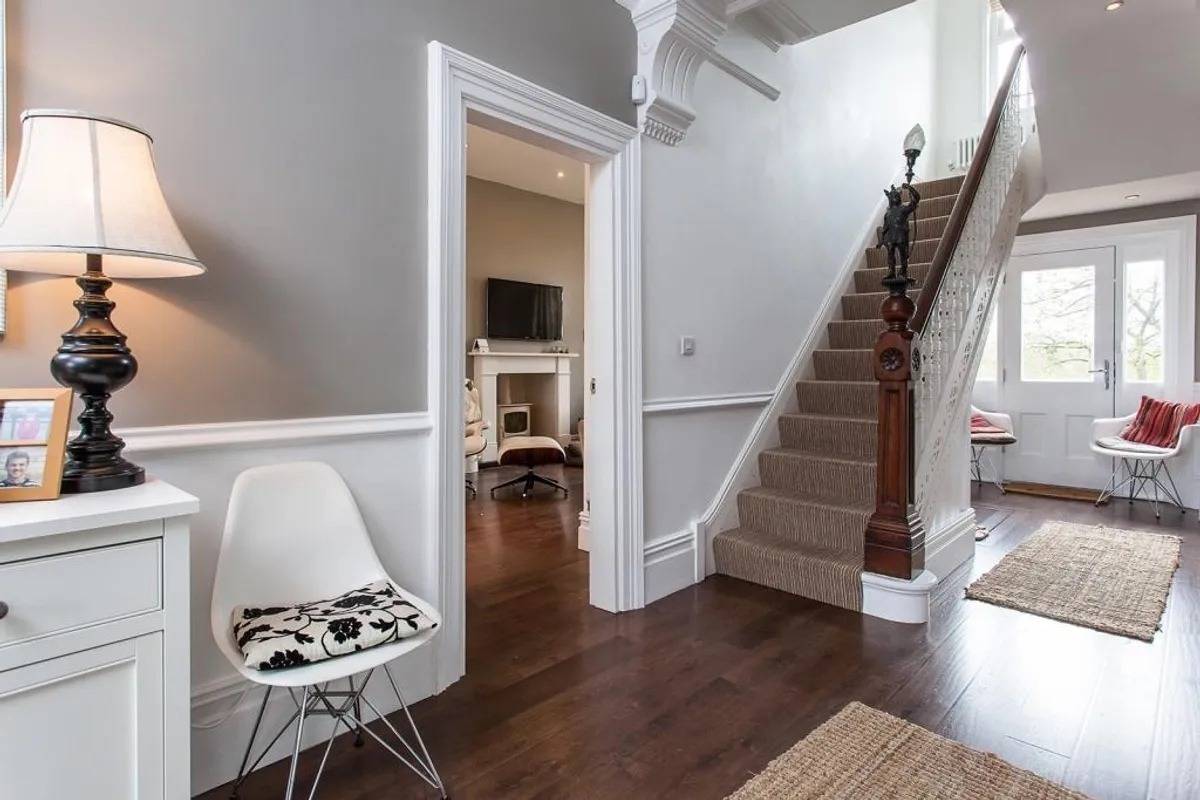 Classic entrance hall and grand staircase shoot location in Stockport SK6 by Love Locations, featuring dark wood flooring and white dado rails.