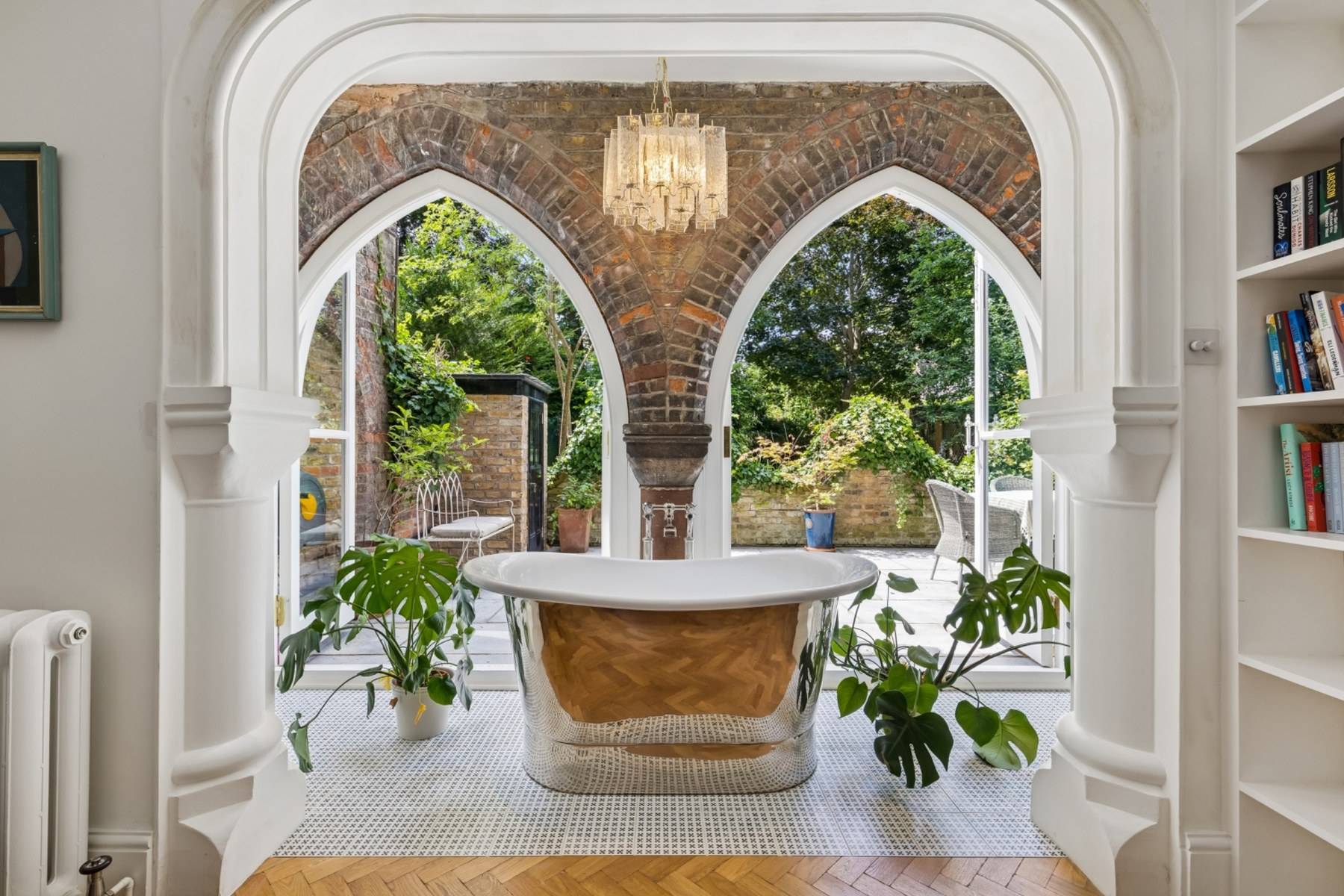 Luxurious copper freestanding bathtub set within gothic brick archways in Hampstead NW3 through Love Locations.