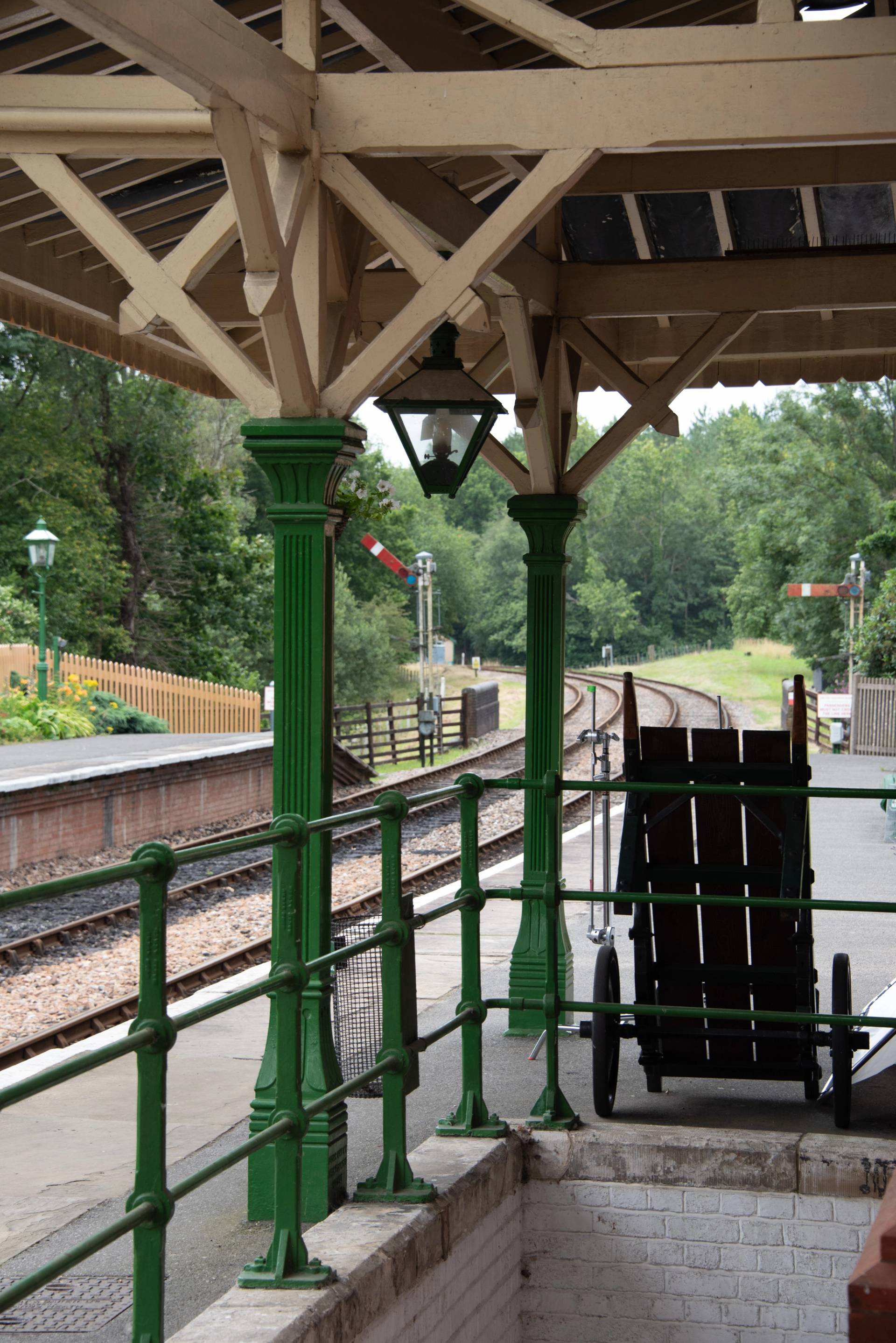 Green canopy pillars overlooking open railway tracks and countryside greenery at Sheffield Park Station, Love Locations TN22.