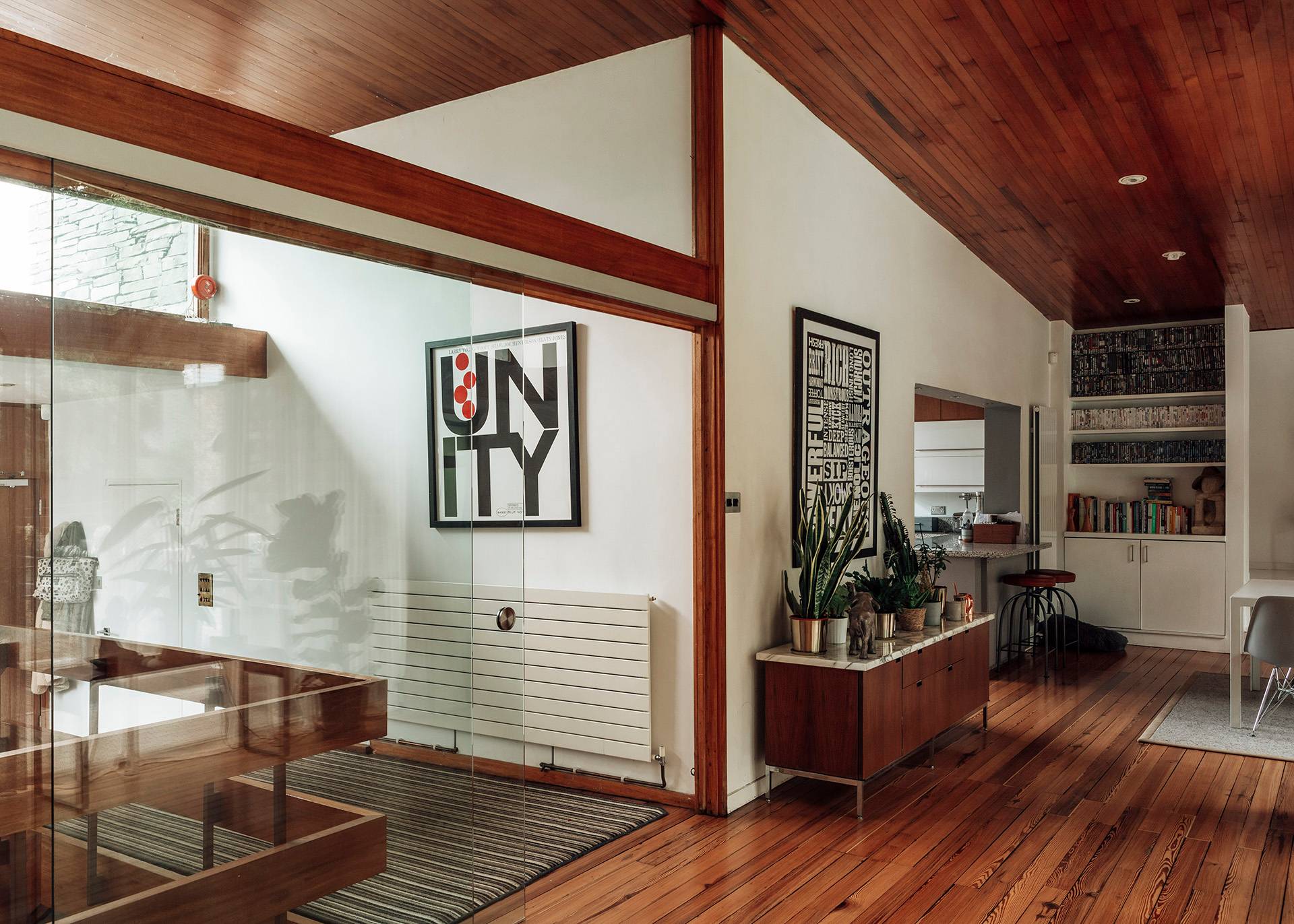 Interior hallway view showcasing warm wooden ceilings, white walls, and retro cabinet units, Love Locations BR1.