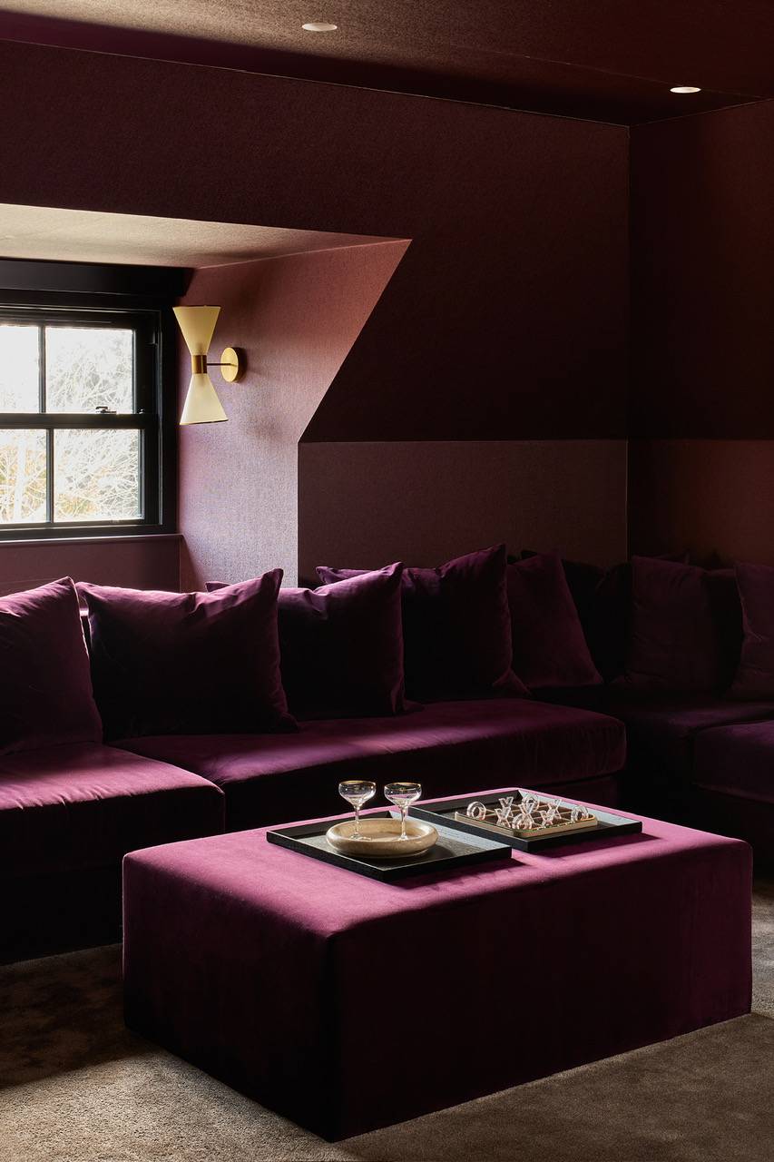 Moody media room painted in a rich plum palette, featuring a deep burgundy velvet sofa, ideal for intimate cinematic scenes and television dramas, Love Locations WD23.