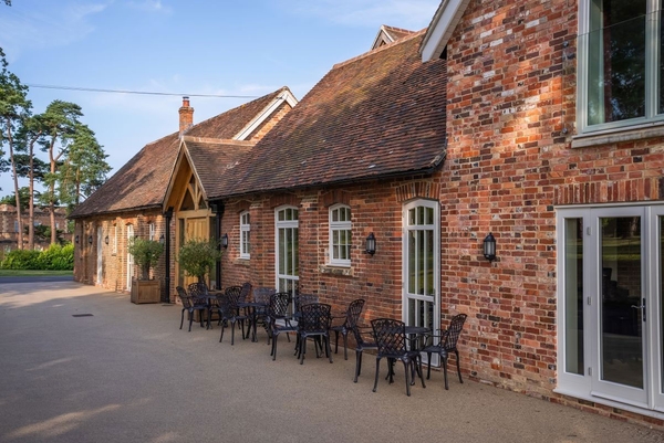 Outdoor terrace seating outside historic brick outbuildings, ideal for lifestyle photography and summer retreats, Love Locations.