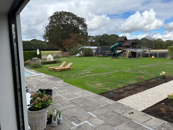 Sprawling garden lawn and outdoor patio location property in Essex CM4 via Love Locations, featuring mature trees and dedicated kids' play equipment.