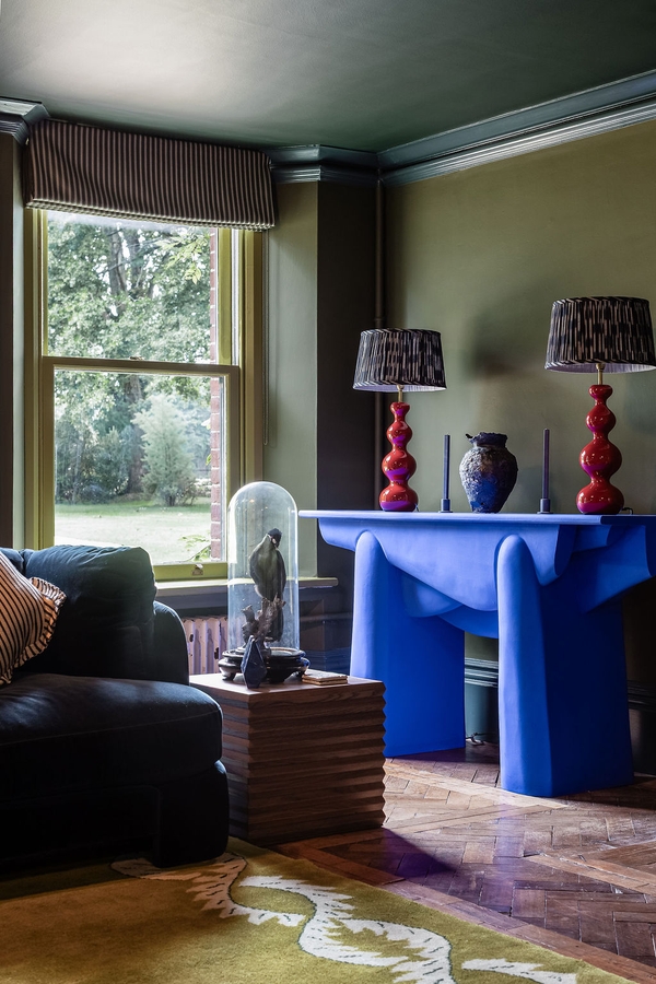 Eclectic olive green sitting room shoot location in Liss Hampshire GU33 from Love Locations, featuring custom cobalt blue side tables and a large traditional sash window.