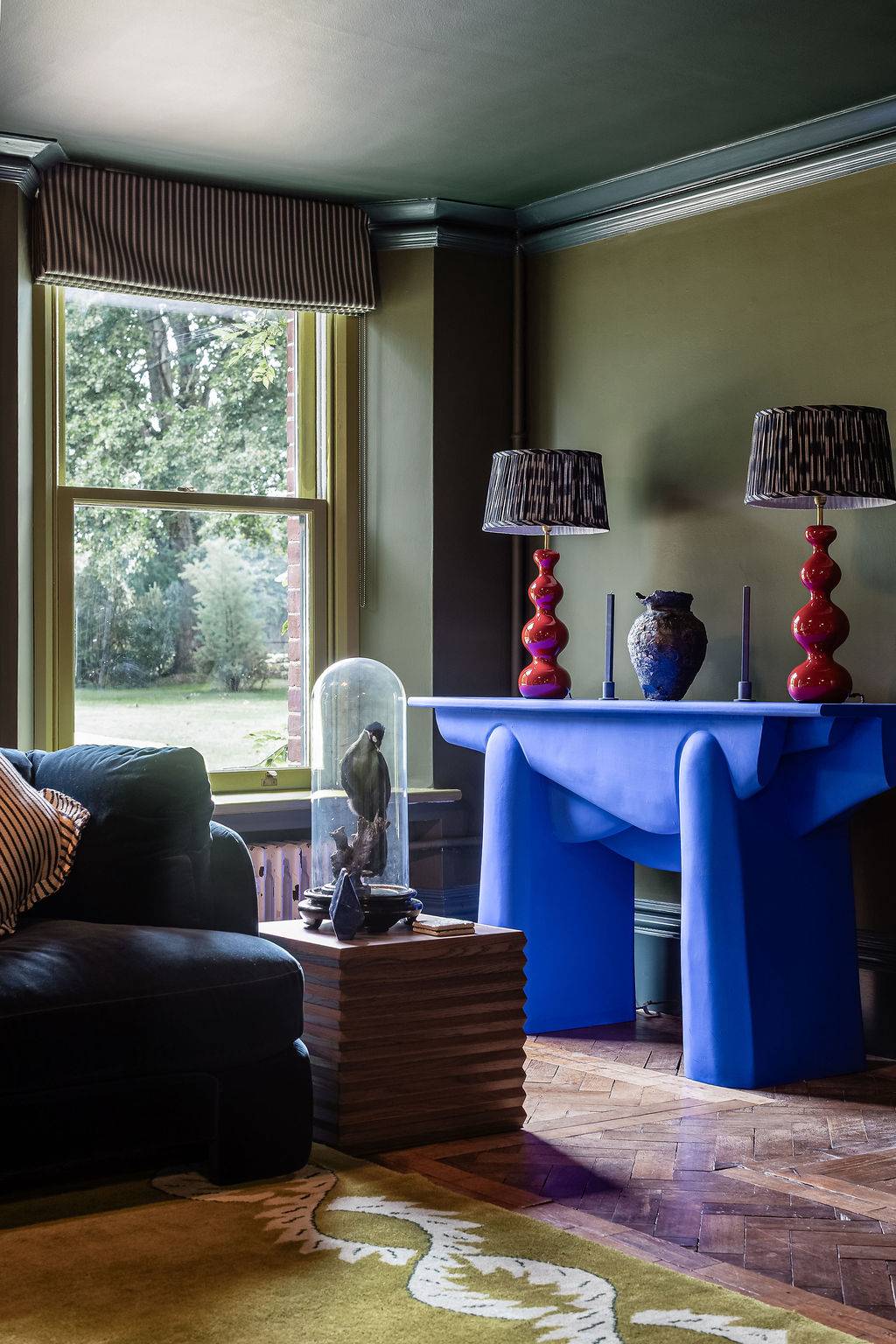Eclectic olive green sitting room shoot location in Liss Hampshire GU33 from Love Locations, featuring custom cobalt blue side tables and a large traditional sash window.