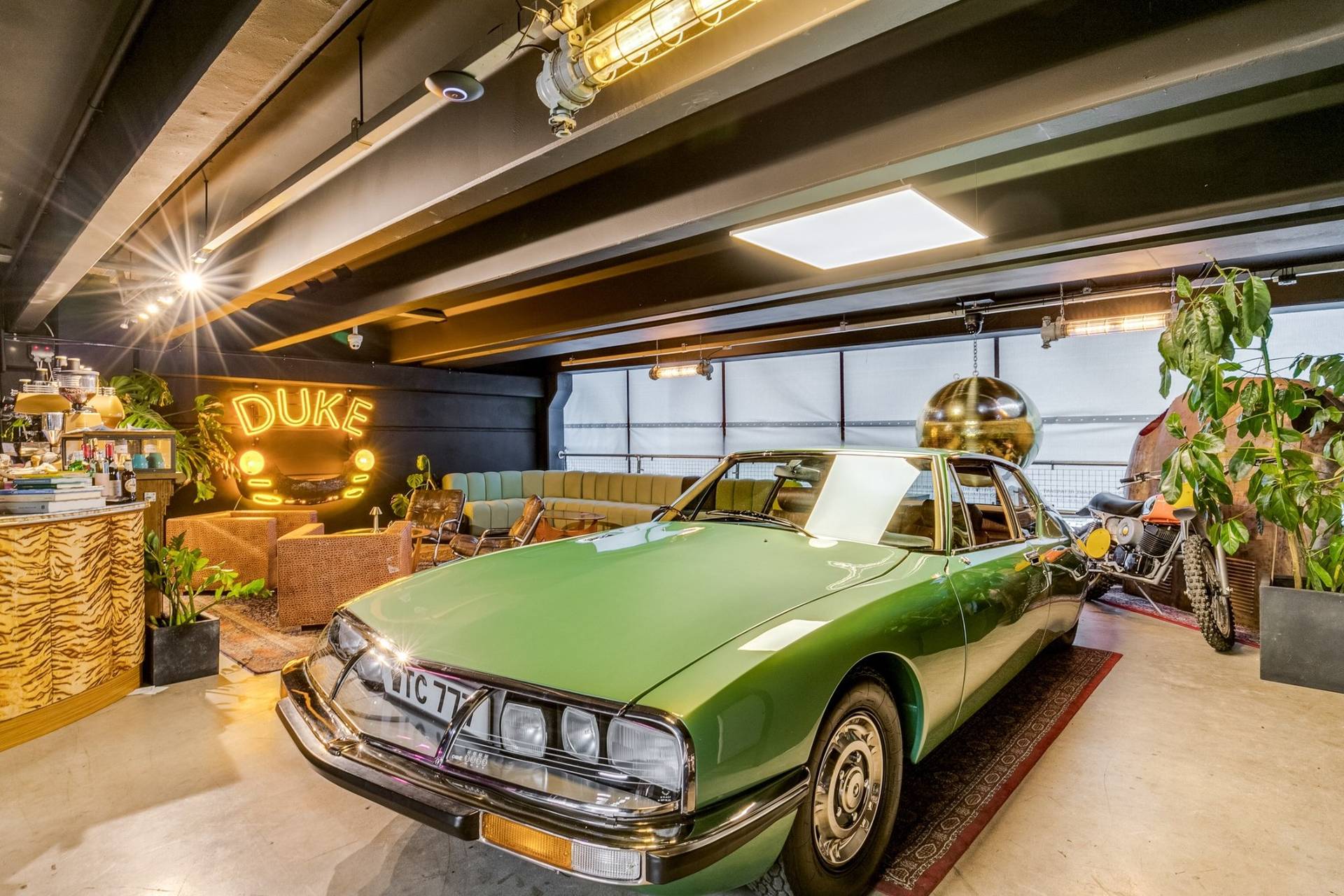 Classic green vintage coupe parked inside a 1950s factory car showroom location house in Brentford TW8 via Love Locations.