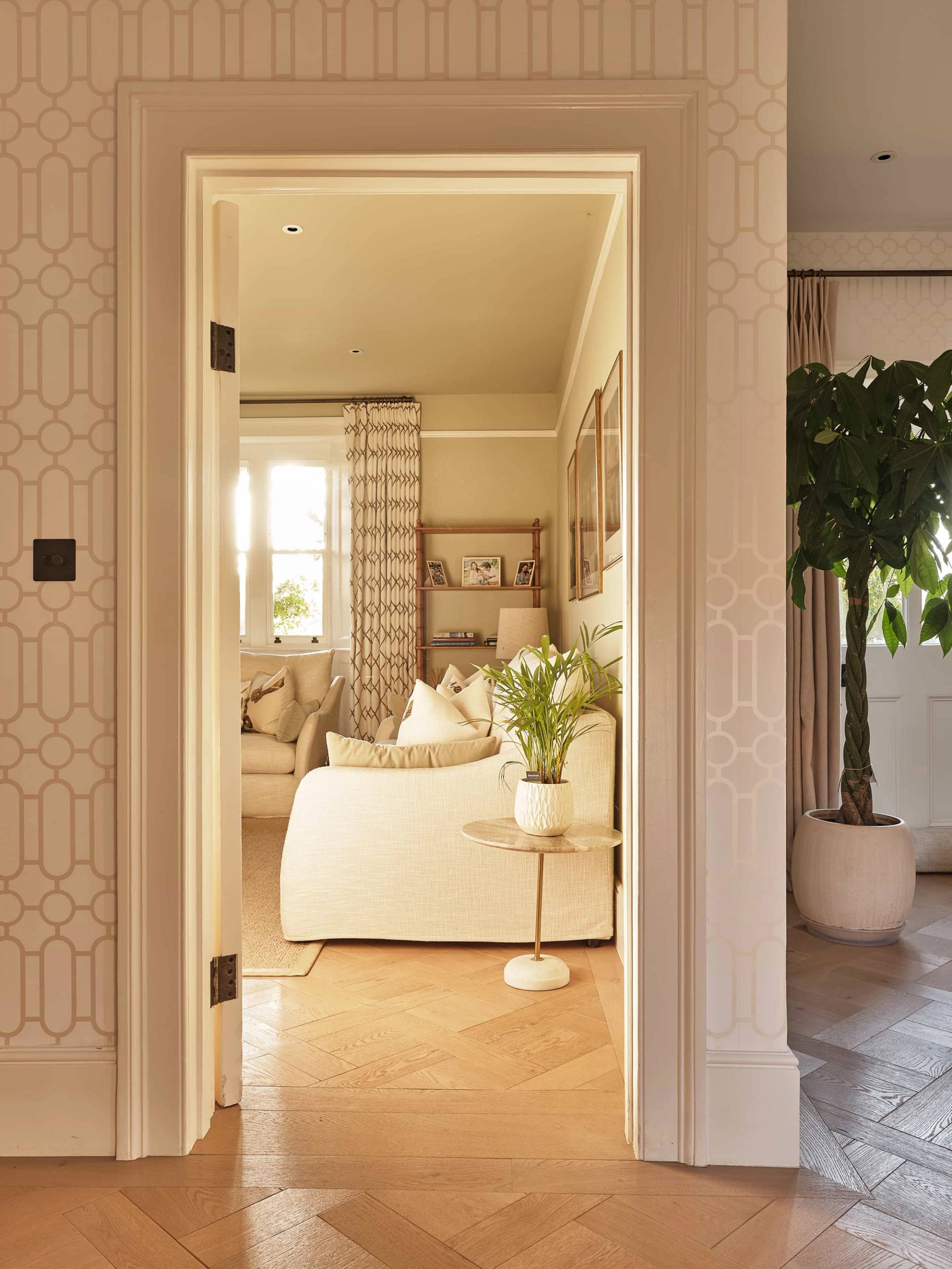 Elegantly styled doorway passage framed by geometric wall panelling looking into a cozy neutral lounge, Love Locations OX7.