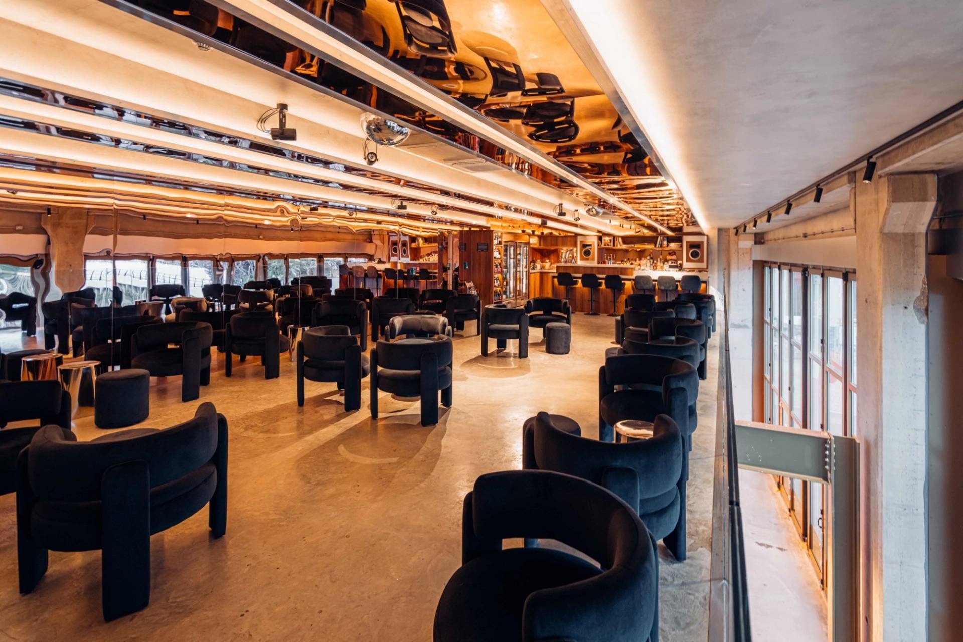 Wide seating layout featuring contemporary velvet armchairs in an audio lounge shoot space from Love Locations.