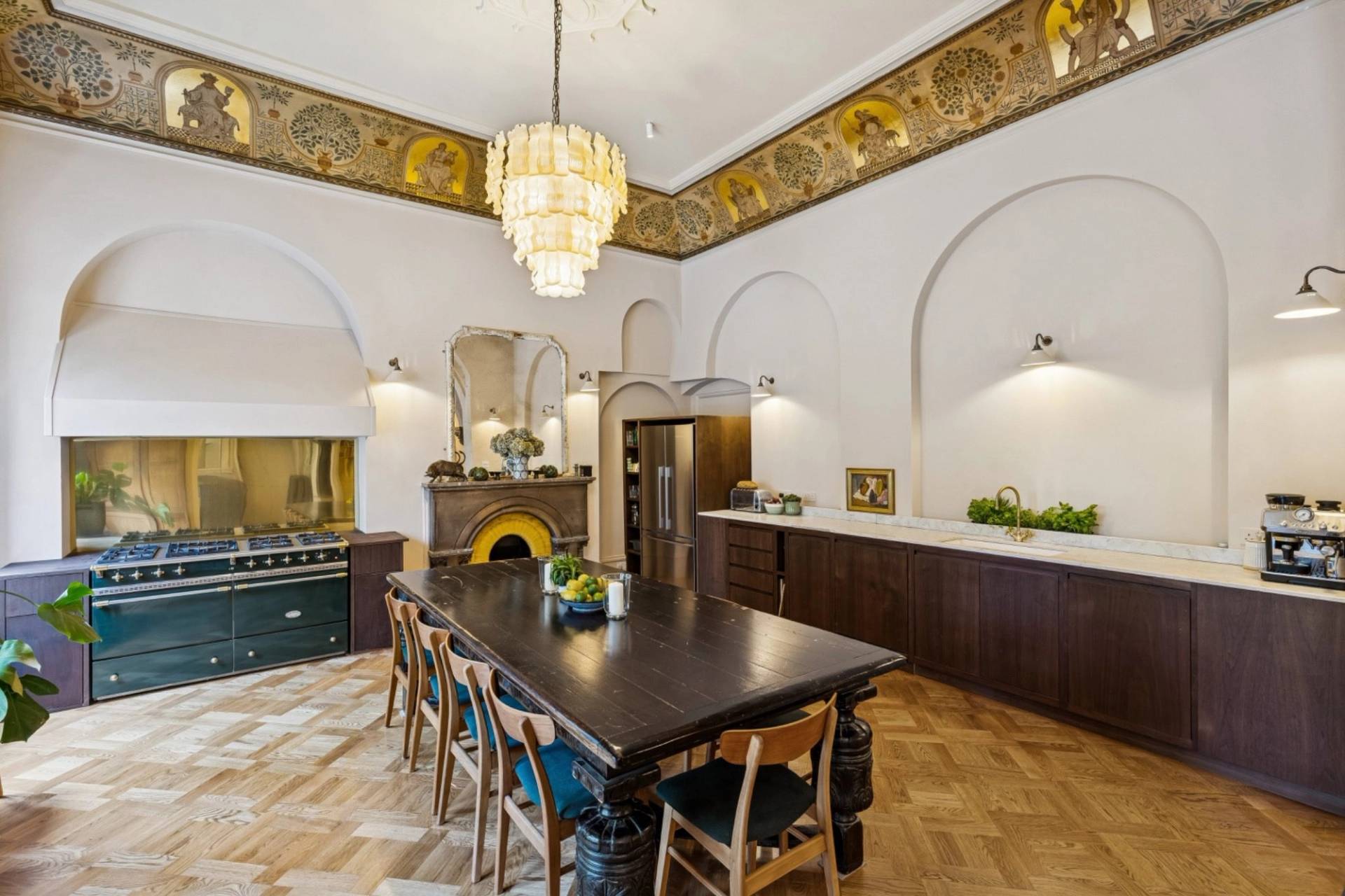 Spacious dining room shoot space in a historic Hampstead NW3 house via Love Locations, showcasing a large dining table, range cooker alcove, and elaborate ceiling gilding.