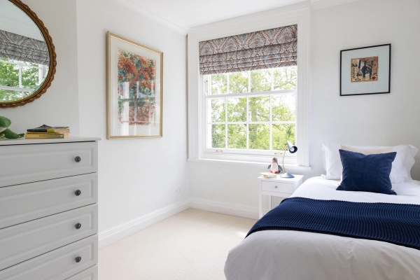Love Locations elegant twin bedroom studio BN44: Airy bedroom corner showcasing clean lines, simple chest of drawers, and a sash window diffusing natural daylight for photography.