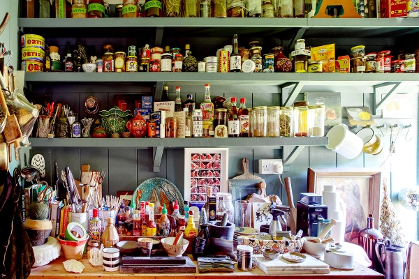 Bespoke pantry shelves stocked with cocktail glassware, spirits, and colorful bottles, Love Locations ME13.
