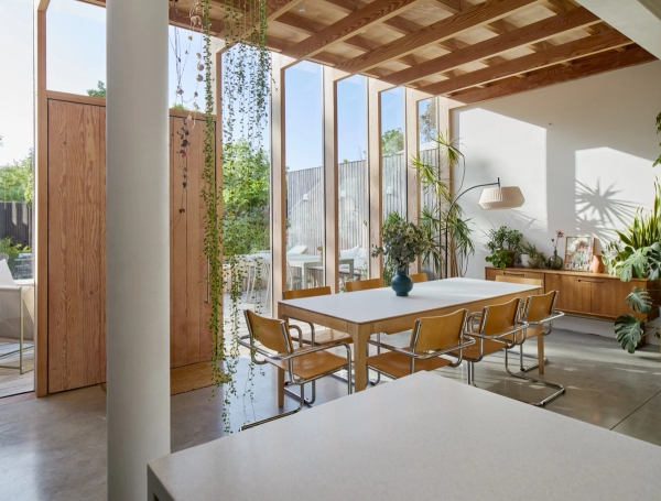 Exposed Douglas fir timber frame extension with white dining table and floor-to-ceiling garden glazing, Love Locations E17.