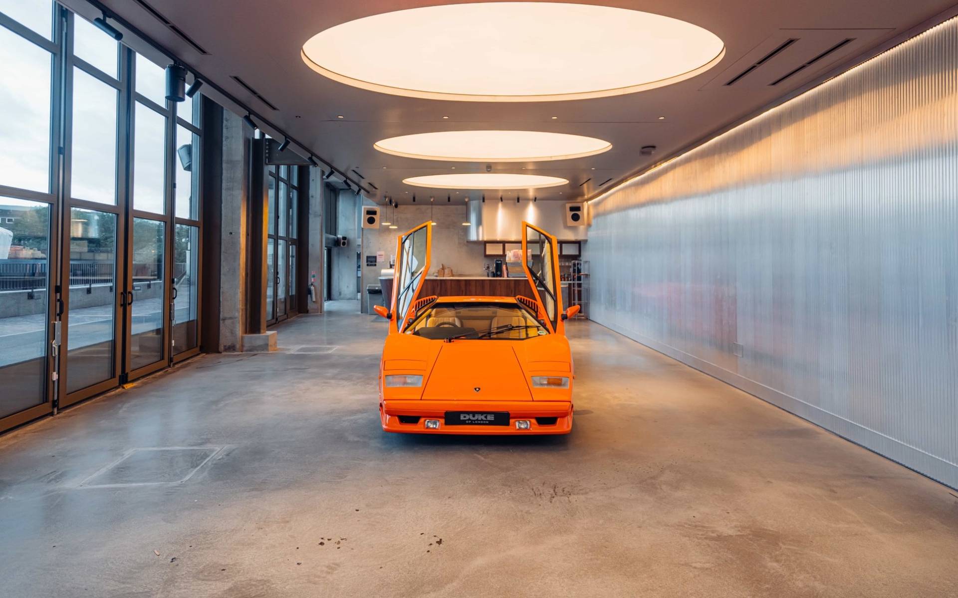 Frontal view of a classic orange Lambo supercar in a commercial venue film location in Brentford TW8 via Love Locations.