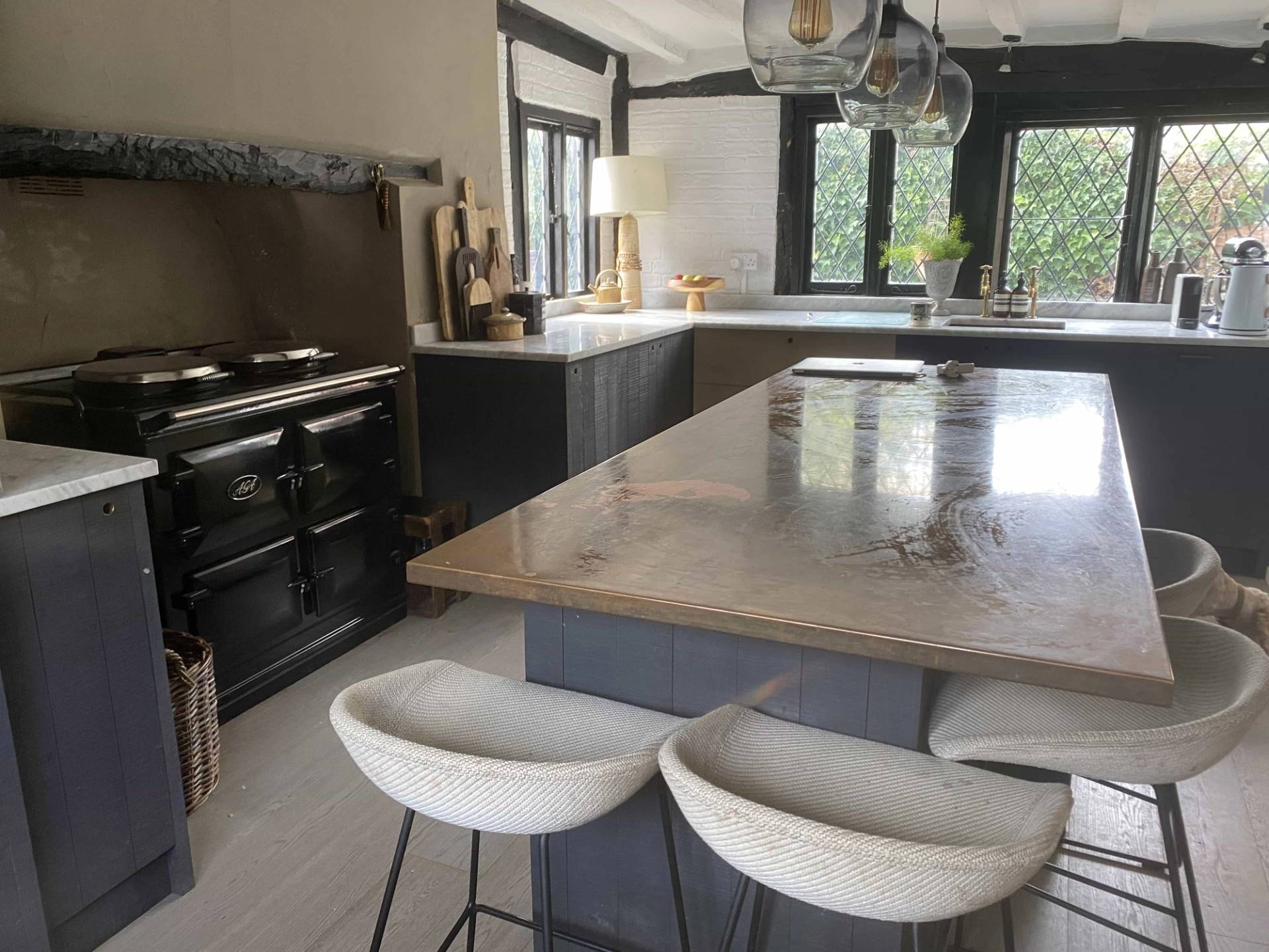 Tudor cottage kitchen and breakfast bar area featuring exposed historic framing and atmospheric lighting, commercial film location via Love Locations.