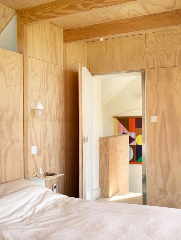 Minimalist plywood bedroom door detail set flush within birch plywood wall cladding, Love Locations E17.