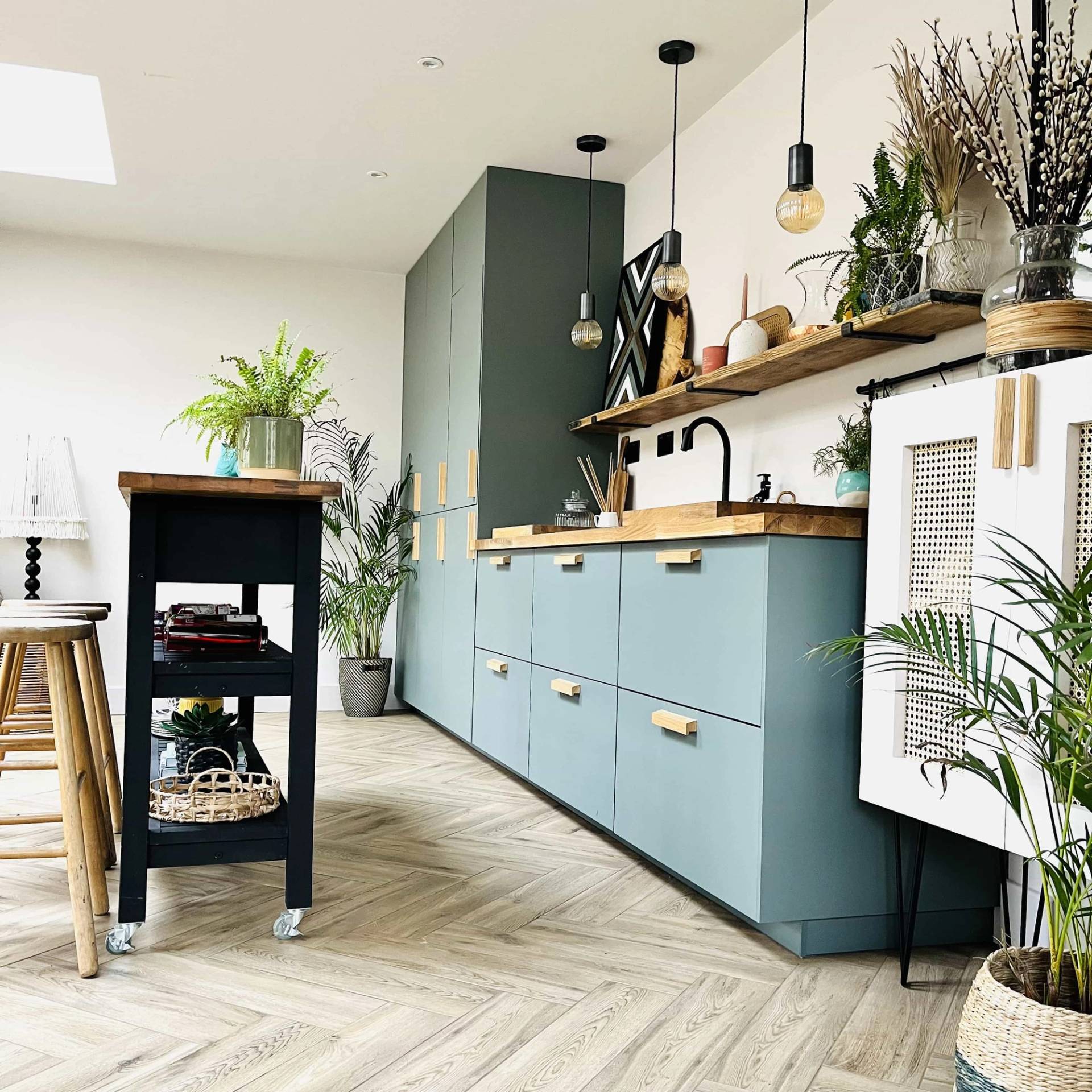Outdoor pool house kitchen area featuring blue cabinetry, white countertops, and parquet patio tiles, Love Locations TW11.