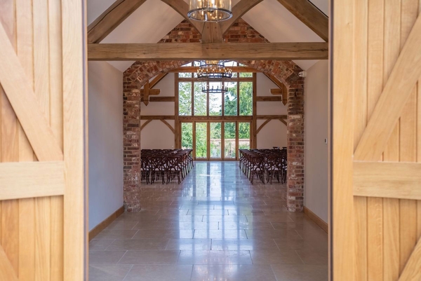 Rustic yet elegant barn wedding ceremony venue with polished floors and brick accents, listed on Love Locations, Haywards Heath.
