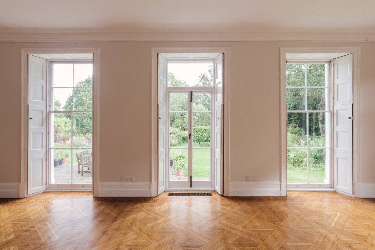 Tall glazed french doors framed by sash windows overlooking estate gardens in a Georgian location home in SE15, ideal for film establishing shots, Love Locations.