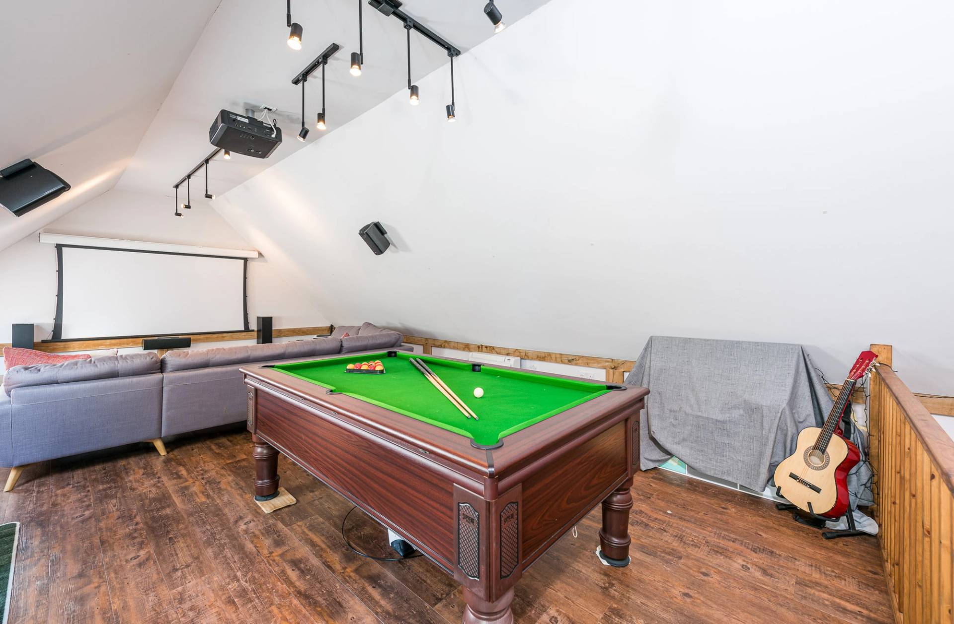 Exclusive home games room shoot space complete with a professional green felt pool table and track lighting, Love Locations.