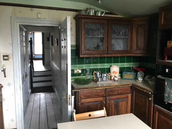 Rustic kitchen shoot location featuring traditional dark wood cabinetry, green wall tiling, and a casual dining counter, ideal for retro cooking media, Love Locations.