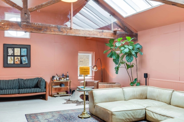 Eclectic apartment set with terracotta walls, rustic beams, and a fiddle-leaf fig tree for editorial media hire, Love Locations.