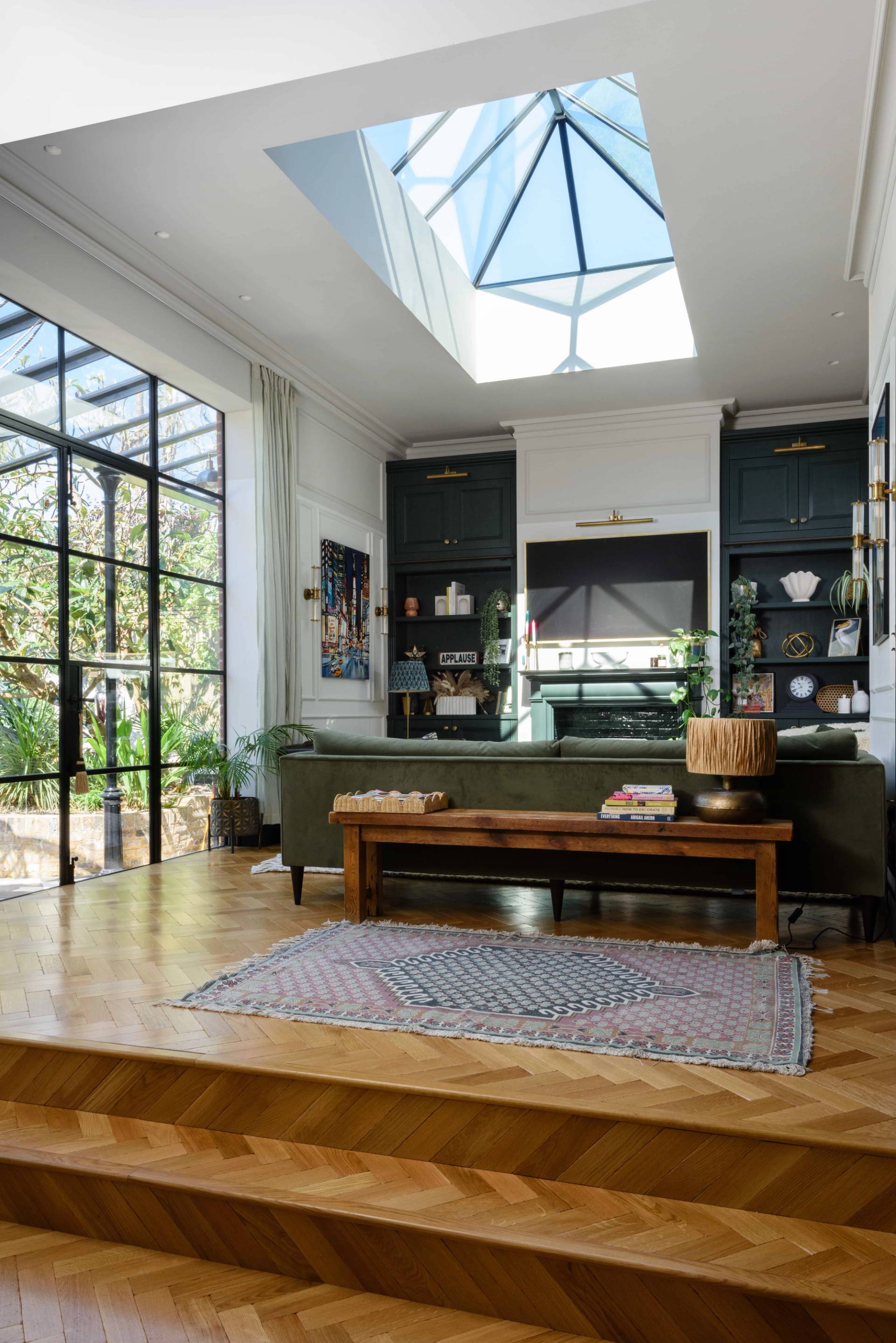 Double-fronted Gothic Victorian location house kitchen in Teddington, TW11 featuring a skylight, parquet flooring, bench seating, and crittall doors via Love Locations.
