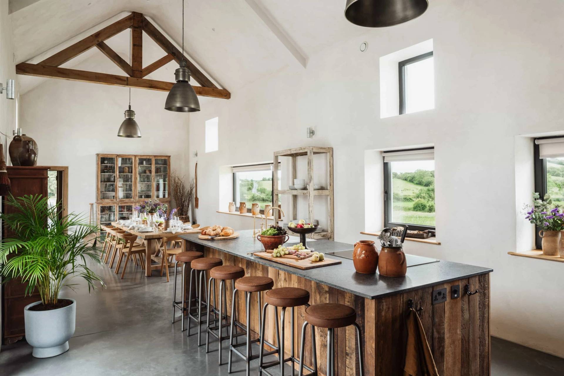Luxury farmhouse kitchen shoot location in Castleblayney County Monaghan Ireland from Love Locations, featuring a long dark island breakfast bar, rustic wood cabinetry, exposed ceiling beams, and concrete floors.