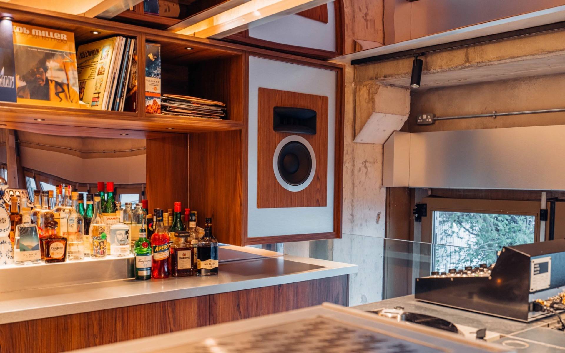 Custom wood-panelled audio counter and built-in speaker setup in a Brentford TW8 venue by Love Locations.