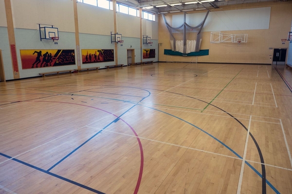 Love Locations school gymnasium shoot space Bristol BS7: High-ceilinged indoor sports court with crisp multi-sport court lines, ideal for team sports filming, athletic apparel ads, and TV scenes.