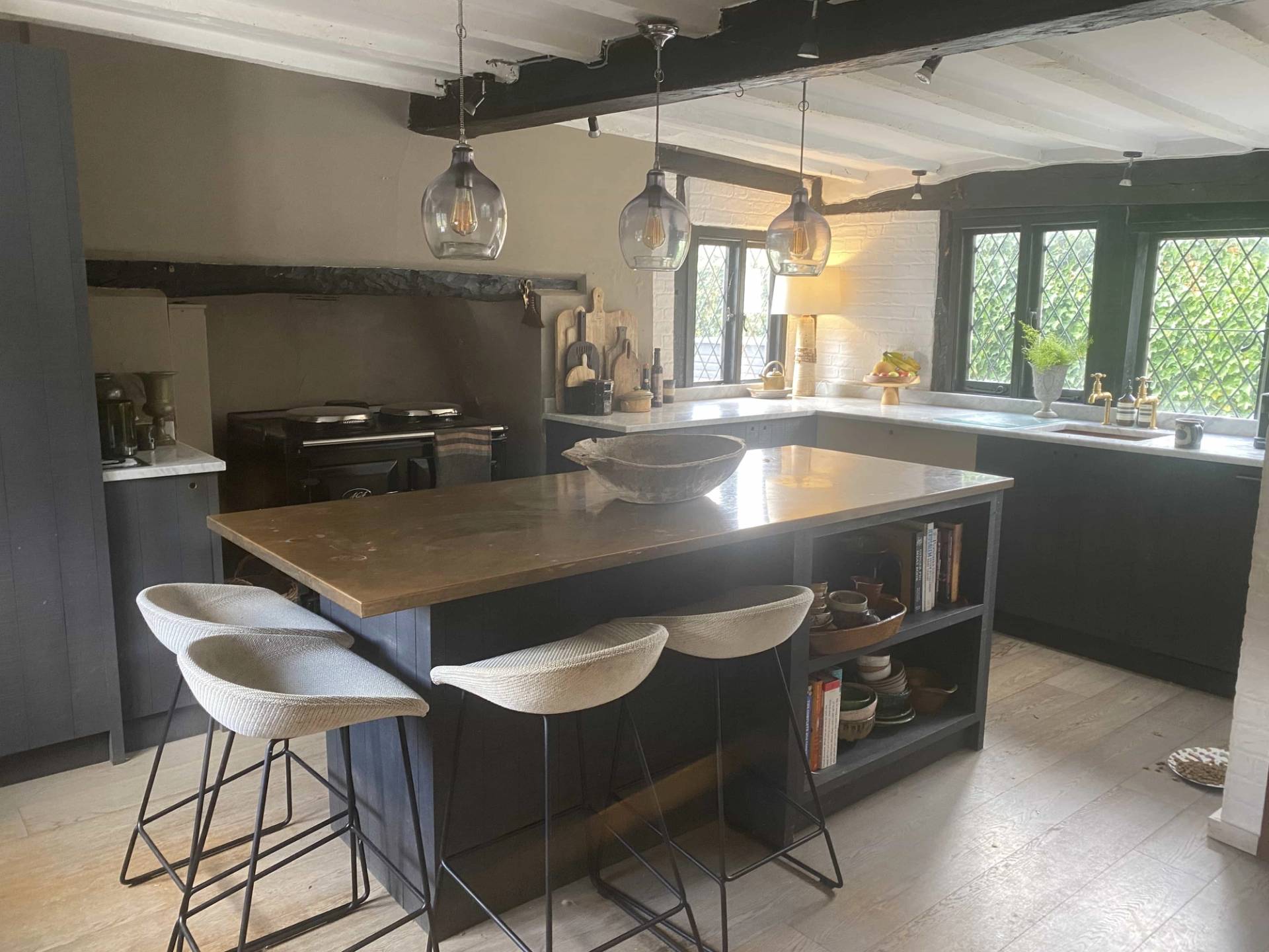Wide angle of a rustic Tudor kitchen shoot location highlighting dark wooden beams, modern bar stools, and heritage character, Love Locations.