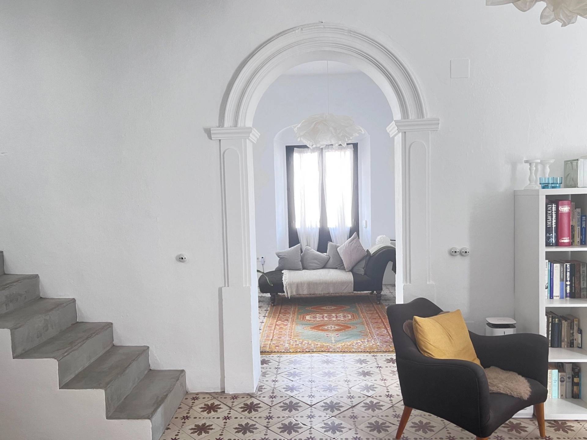 Characterful Spanish living room location in Calle Sevilla Jimena de la Frontera by Love Locations, showcasing a dramatic white plaster archway opening into an inner lounge.