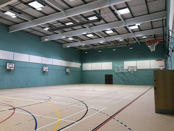 Love Locations school sports hall Reading RG30: Sprawling indoor gymnasium floor with basketball hoops and marked court lines, excellent for sports commercials and music videos.