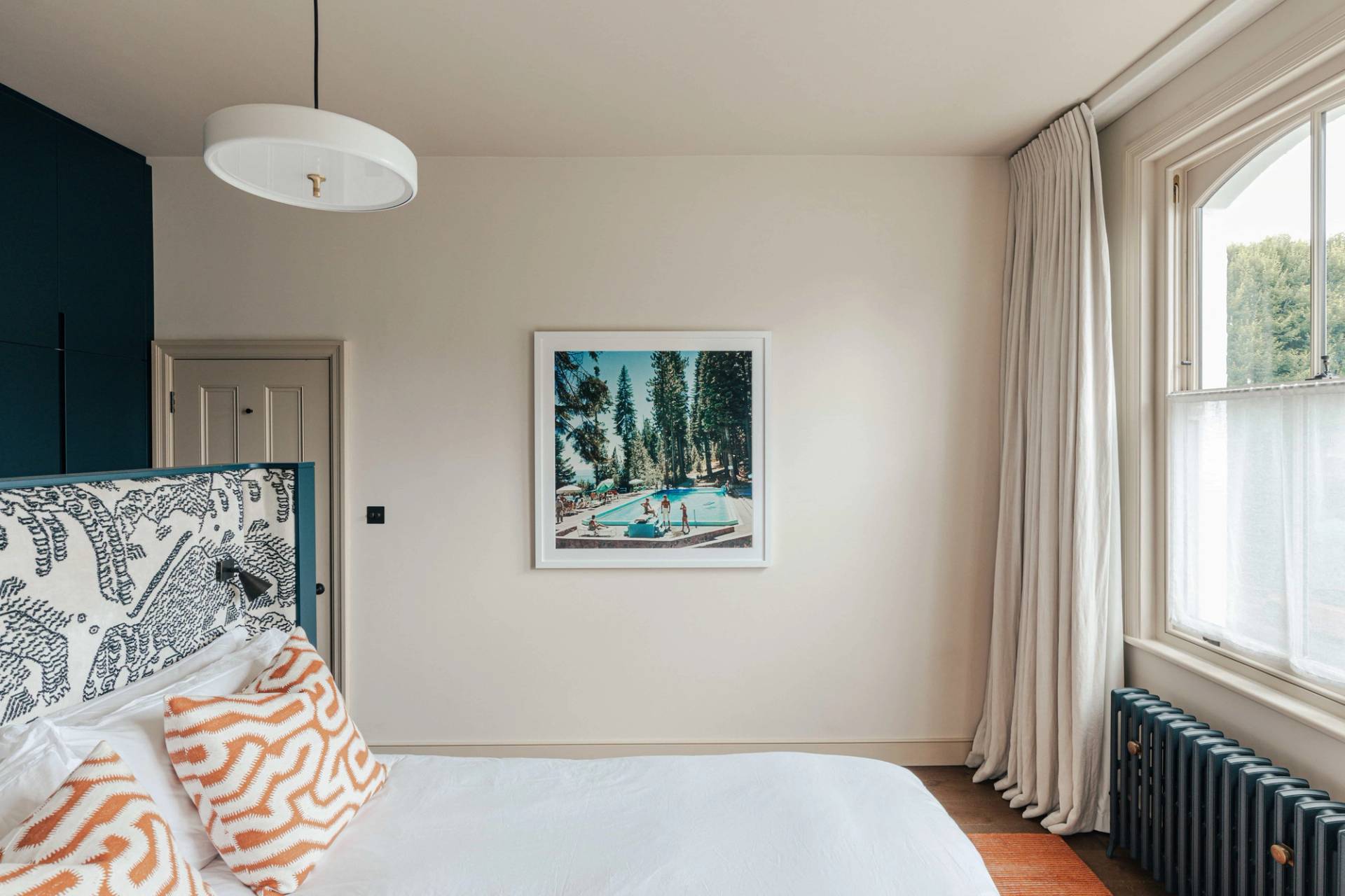Neutral bedroom with light walls, minimalist artwork, and sheer linen window curtains, Love Locations.
