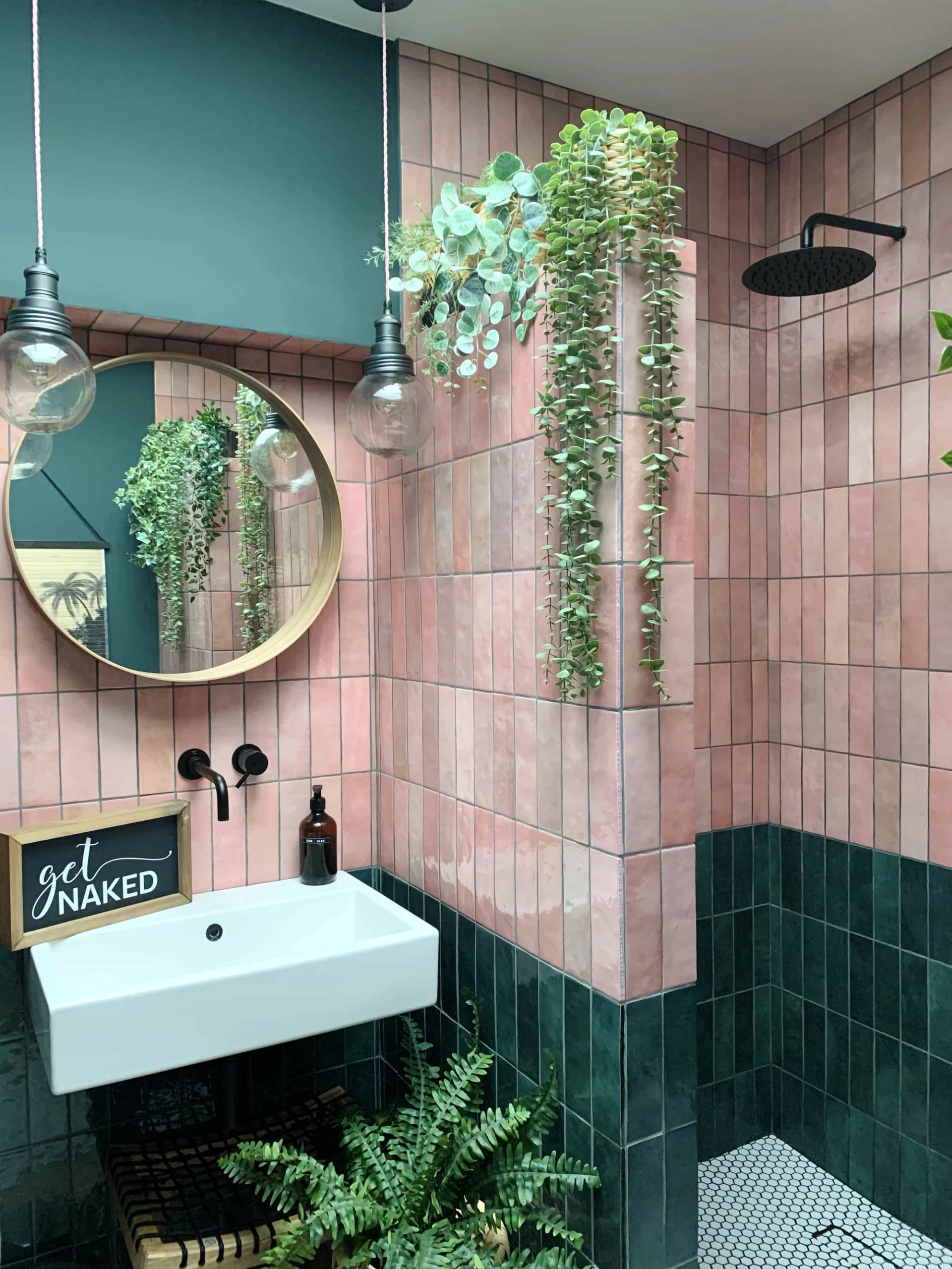 Outdoor shower setup with vertical pink wall tiles, dark green tiles, and round mirror in a garden patio, Love Locations TW11.