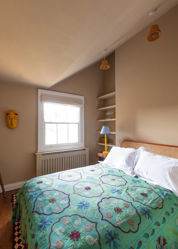 Period property bedroom location in Westminster London SW1V by Love Locations, showing a sash window, radiator, built-in shelving, and a double bed with a green patterned quilt.