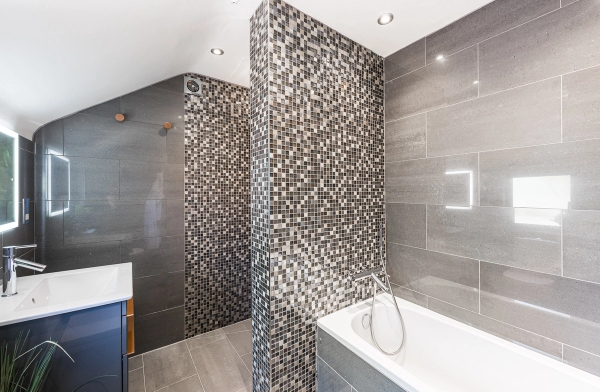 Luxury grey tiled family bathroom location with a built-in bathtub and modern square shower screen, Love Locations.