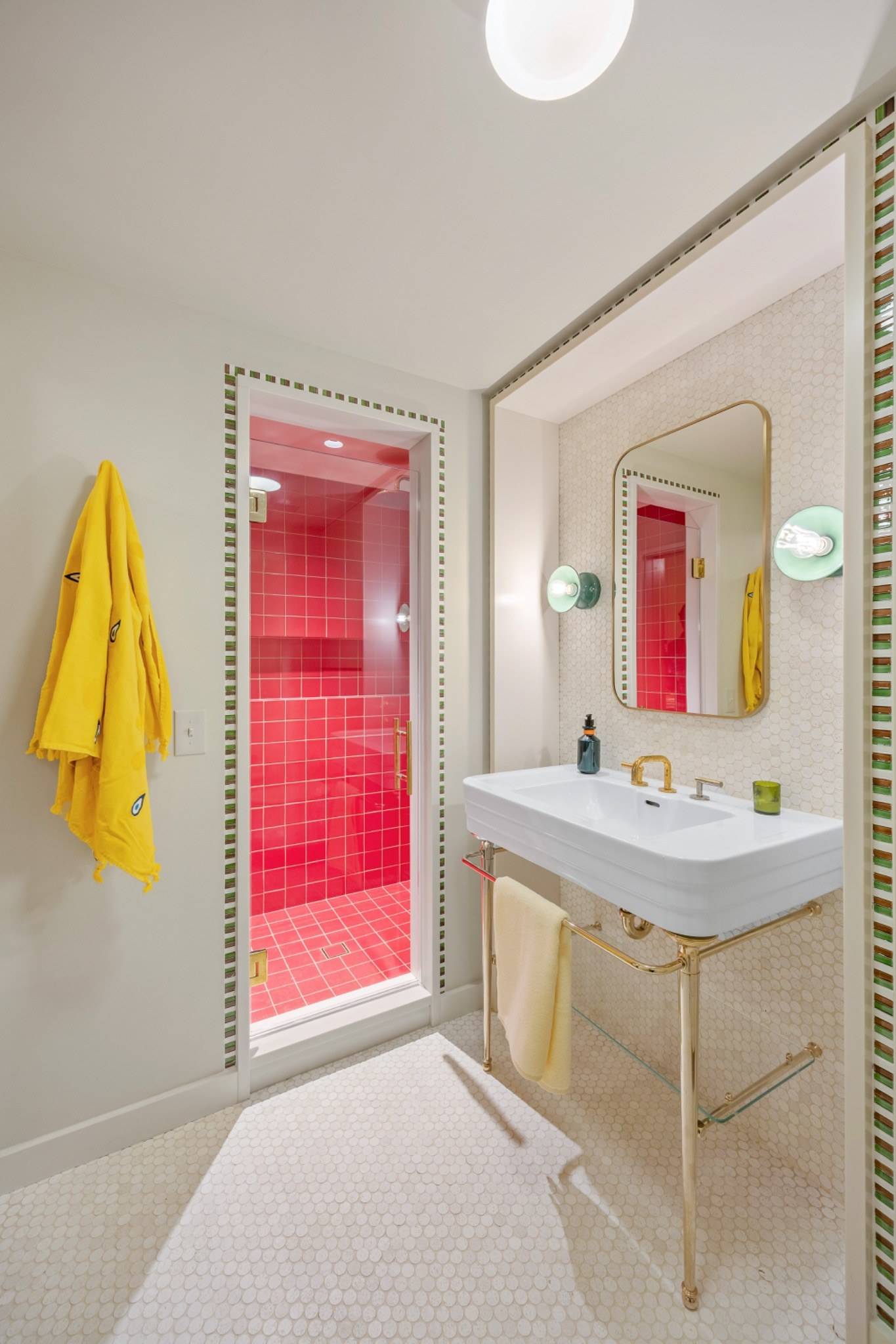 Bold red tiled luxury bathroom shoot location in Boerum Hill Brooklyn NY 11217 through Love Locations, featuring a white pedestal sink and vibrant yellow hanging towels.
