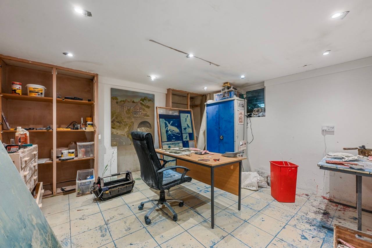 Artist studio or home office workspace with a wooden desk, office chair, and display shelving, ideal for creative corporate shoots, Love Locations E7.