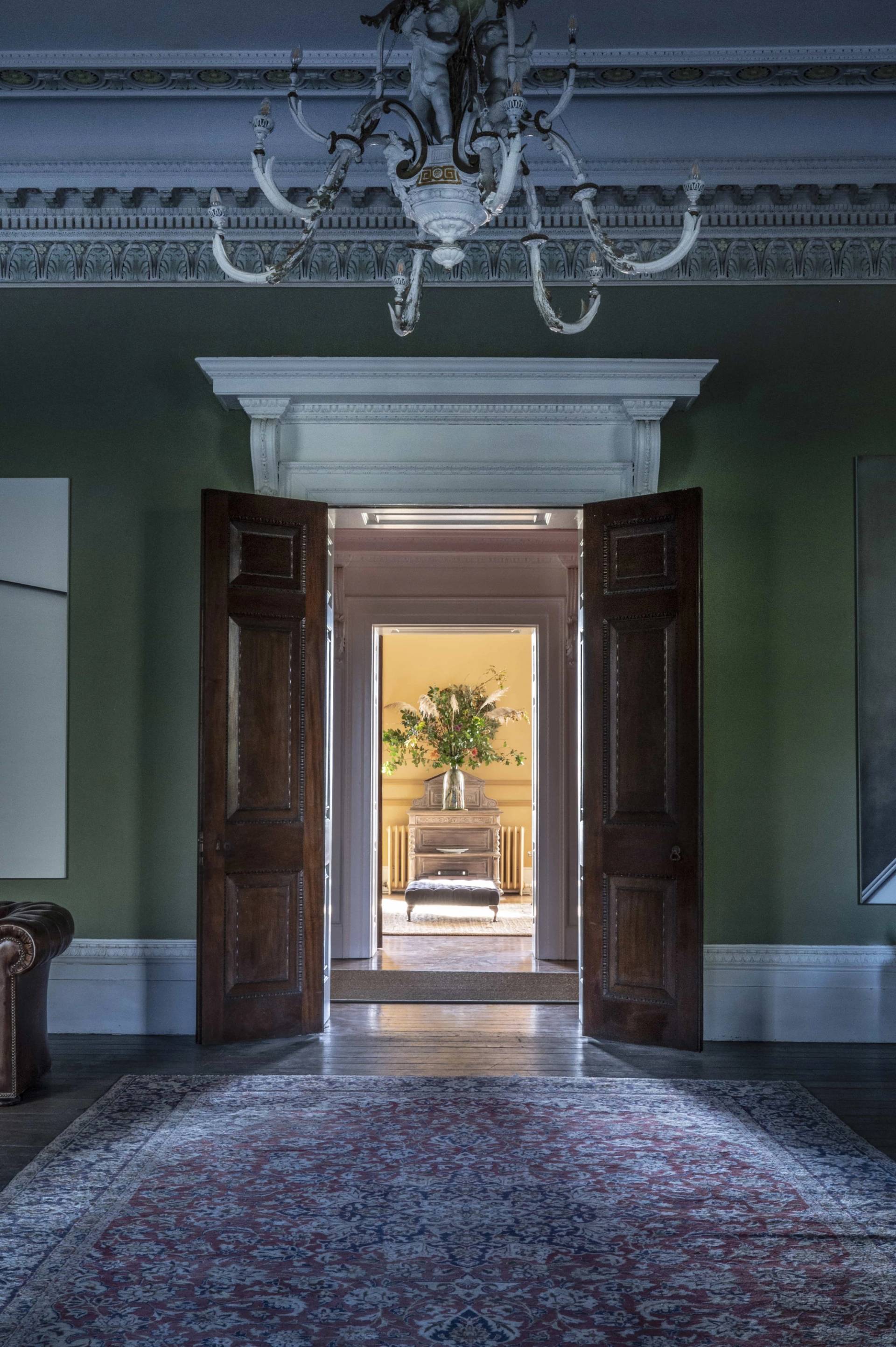 Victorian manor shoot location in Tugby, LE7 featuring tall double panelled doors leading into a sage green drawing room, ideal for period drama scenes via Love Locations.