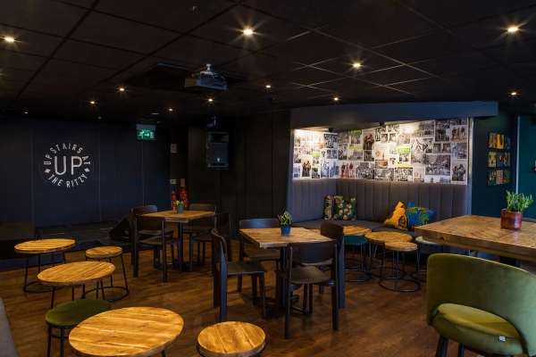Multi-functional venue space layout with flexible seating, parquet-style flooring, and dark moody interiors at The Ritzy Brixton, perfect for corporate video shoots, Love Locations SW2.